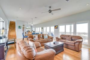 a living room with leather couches and a table at Wake Up to Waves | Oceanfront Surfside home in Surfside Beach