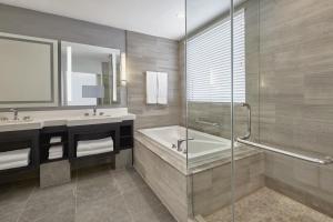 a bathroom with a tub and a sink and a shower at Loews Miami Beach Hotel in Miami Beach