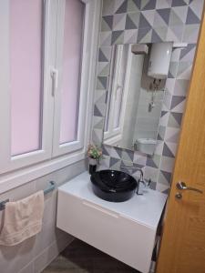 a bathroom with a black sink and a mirror at La de Fredyy - Tres Marias Apartments in Redondela