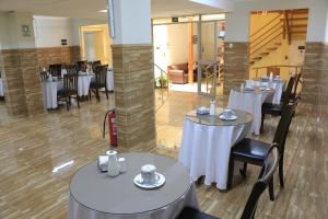 a restaurant with white tables and chairs and a staircase at Hotel Garden Latorre in Iquique