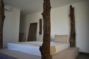 una camera da letto con un letto con un albero di Villa Julito, Kiwengwa a Kiwengwa Altre 52 foto