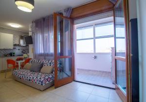 uma sala de estar com um sofá e uma porta de vidro deslizante em Bologna Fair Expo Apartment em Bolonha