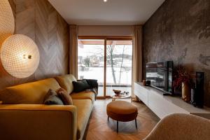 a living room with a couch and a television at Potoku Szum A08 - Białka Spa & Resort in Białka Tatrzańska