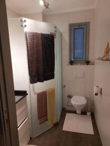 y baño con aseo, ventana y toallas. en Lovely bedroom apartment TBR, en Hurghada
