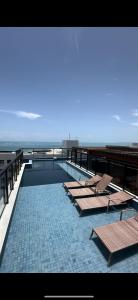 卡貝德盧的住宿－Flat Praiano Aconchegante，一个带躺椅的游泳池和海滩