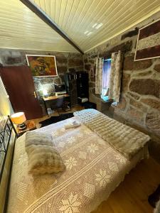 a bedroom with a bed and a stone wall at Casa da Eira 