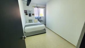 ein kleines Schlafzimmer mit einem Bett und einem Fenster in der Unterkunft SUITE GRANDE in Santa Marta