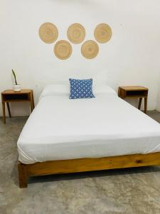 1 dormitorio con 1 cama con 3 platos en la pared en Casa Karma, en Puerto Escondido