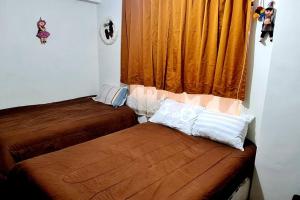 een slaapkamer met 2 bedden en een raam met oranje gordijnen bij Atahuallpa ukumary in Cuzco