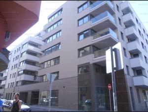 a woman standing in front of a tall building at Kőris Pool Apartments in Budapest