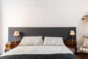 a bedroom with a bed with a black headboard and two lamps at Centro Storico di Genova a 15 minuti, Sweet Home in Genova