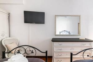 a bedroom with a dresser with a mirror and a tv at Centro Storico di Genova a 15 minuti, Sweet Home in Genoa