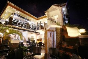 un restaurant avec des tables et des chaises le soir dans l'établissement Coron Bancuang Mansion, à Coron