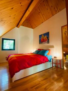 a bedroom with a red bed with a wooden ceiling at Waterfront Chalet Serendipity Hideaway - Cachette Sérendipité - Swim SUPs BBQ Relax w Wifi in Chertsey