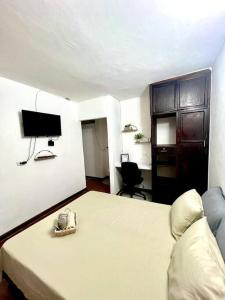 um quarto com uma cama e uma televisão de ecrã plano em ApartaEstudio en Pereira em Pereira