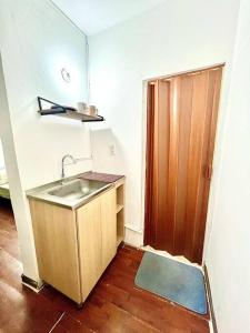 uma cozinha com um lavatório e uma porta de madeira em ApartaEstudio en Pereira em Pereira