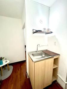 uma pequena cozinha com um lavatório e uma mesa em ApartaEstudio en Pereira em Pereira