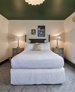 a bedroom with a large white bed with two night stands at The Lenox Collection in Lenox