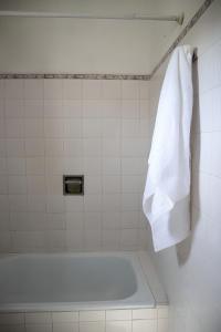 Baño blanco con bañera y toalla en Refugio de plata, La Florida en Munro