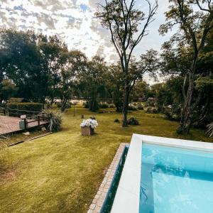 uitzicht op een tuin met een zwembad bij Hotel El Sauce in Santa Rosa de Calamuchita