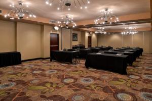 a conference room with tables and chandeliers at Holiday Inn Fort Worth North- Fossil Creek, an IHG Hotel in Fort Worth