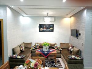 ein Wohnzimmer mit einem Sofa und einem Tisch in der Unterkunft Appartement de luxe in Kenitra