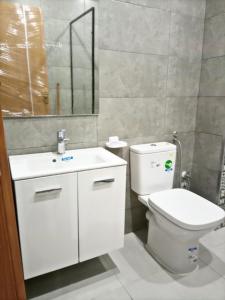 ein Badezimmer mit einem WC, einem Waschbecken und einem Spiegel in der Unterkunft Appartement de luxe in Kenitra