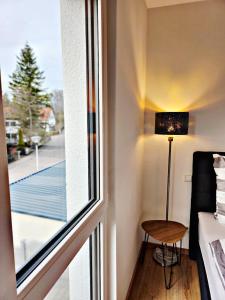 a room with a window and a table and a lamp at Lions Place Premium Apartments BUSINESS optionaler Zugang zum SPA- Bereich in Heidenheim