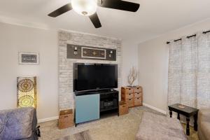 a living room with a flat screen tv and a brick fireplace at Getaway on Gossett in Spartanburg