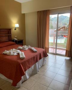 een hotelkamer met een bed met handdoeken erop bij Hotel El Sauce in Santa Rosa de Calamuchita