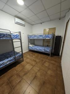 a room with three bunk beds and a tile floor at Acho Rancho in Murcia