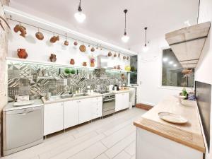 a kitchen with white cabinets and stainless steel appliances at Villa con piscina mozzafiato, giardino e barbecue in Polignano a Mare