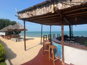 a bar on the beach with a view of the ocean at Calamari Beach Resort in Zanzibar City