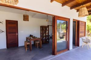an open living room with a table and chairs at Casa com piscina na tranquilidade de Barra Grande in Barra Grande
