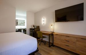 a bedroom with a bed and a desk with a television at Kokopelli Inn Sedona, Trademark Collection by Wyndham in Sedona