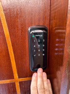 a person is pressing a door button with their hand at BORA BORA RESIDENCE in Joinville