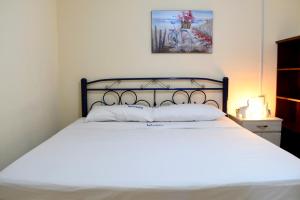 a bedroom with a white bed with a black frame at Departamento 2, Comodo y hogareño in Tehuacán