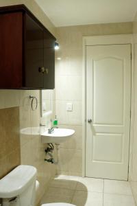 a bathroom with a white toilet and a sink at Departamento 2, Comodo y hogareño in Tehuacán