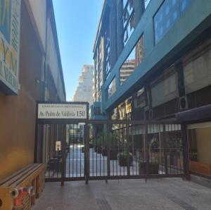 a gate with a sign in front of some buildings at Apart Hotel Inga Providencia in Santiago