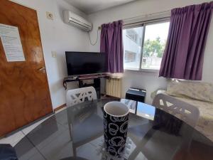 a living room with a glass table and a tv at Cozy I monoambiente en ciudad de Mendoza in Mendoza