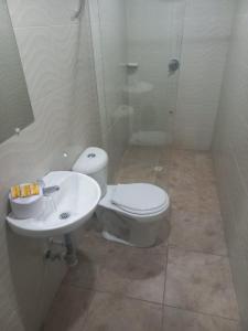 a bathroom with a toilet and a sink at Casa Hotel Mónaco in Bogotá