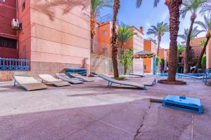 a row of lounge chairs in a courtyard with palm trees at RIAD TAWSALANE in Marrakesh +12 photos