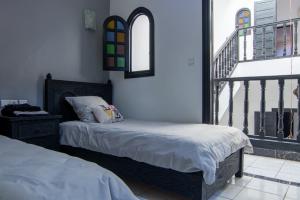 een slaapkamer met 2 bedden en een balkon bij RIAD TAWSALANE in Marrakesh