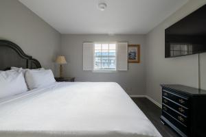 a bedroom with a large white bed and a window at French Quarter Suites Hotel in New Orleans +86 photos