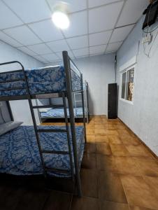 a room with three bunk beds in a room with a hallway at Acho Rancho in Murcia