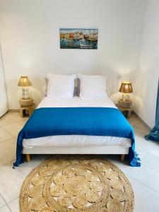 a bedroom with a bed with a blue bedspread and two lamps at Maison de pêcheur in Grimaud