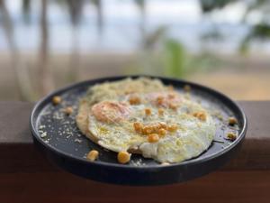 a pizza sitting on top of a black plate at Irana Pacific Hotel in Nuquí