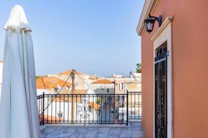 - Balcón con puerta y sombrilla en Casa di Emmanuel, en Kalymnos