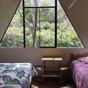 una camera da letto con una grande finestra con un letto e un tavolo di Madera Verde Ecolodge a Maranura