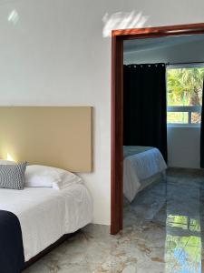 ein Schlafzimmer mit einem Spiegel, einem Bett und einem Fenster in der Unterkunft DUNAMIS HOTEL 